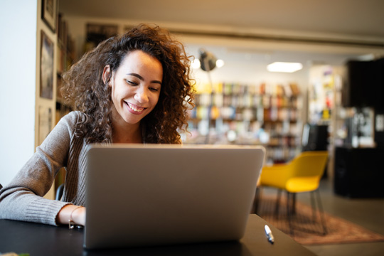 Woman at her desk smiling down at her computer
